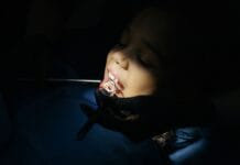 Jak przebiega wizyta adaptacyjna u dentysty dziecięcego i dlaczego nie warto z nią zwlekać do bólu Zbliżenie na dziecko podczas badania stomatologicznego w gabinecie