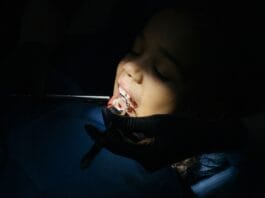 Jak przebiega wizyta adaptacyjna u dentysty dziecięcego i dlaczego nie warto z nią zwlekać do bólu Zbliżenie na dziecko podczas badania stomatologicznego w gabinecie