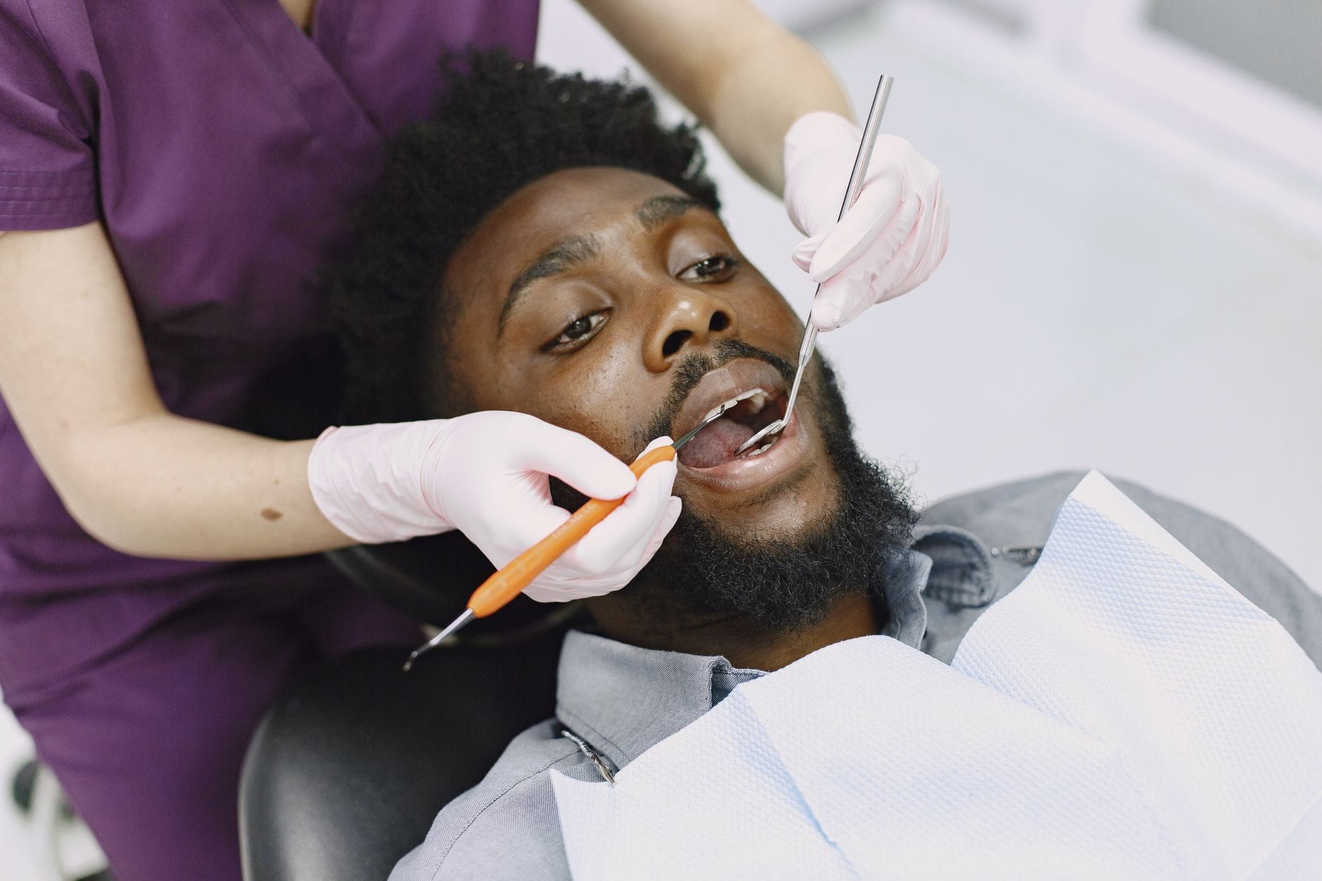 Dentysta bada uzębienie mężczyzny podczas rutynowej kontroli