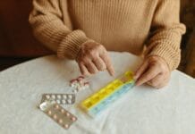 Zarządzanie lekami u seniora: jak uniknąć groźnych interakcji i wspierać skuteczność leczenia przewlekłego Senior układa leki w tygodniowym organizerze na stole w domu