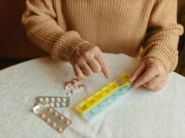 Zarządzanie lekami u seniora: jak uniknąć groźnych interakcji i wspierać skuteczność leczenia przewlekłego Senior układa leki w tygodniowym organizerze na stole w domu