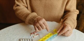 Zarządzanie lekami u seniora: jak uniknąć groźnych interakcji i wspierać skuteczność leczenia przewlekłego Senior układa leki w tygodniowym organizerze na stole w domu