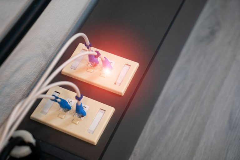 Zbliżenie na porty Ethernet z podłączonymi kablami i diodą LED